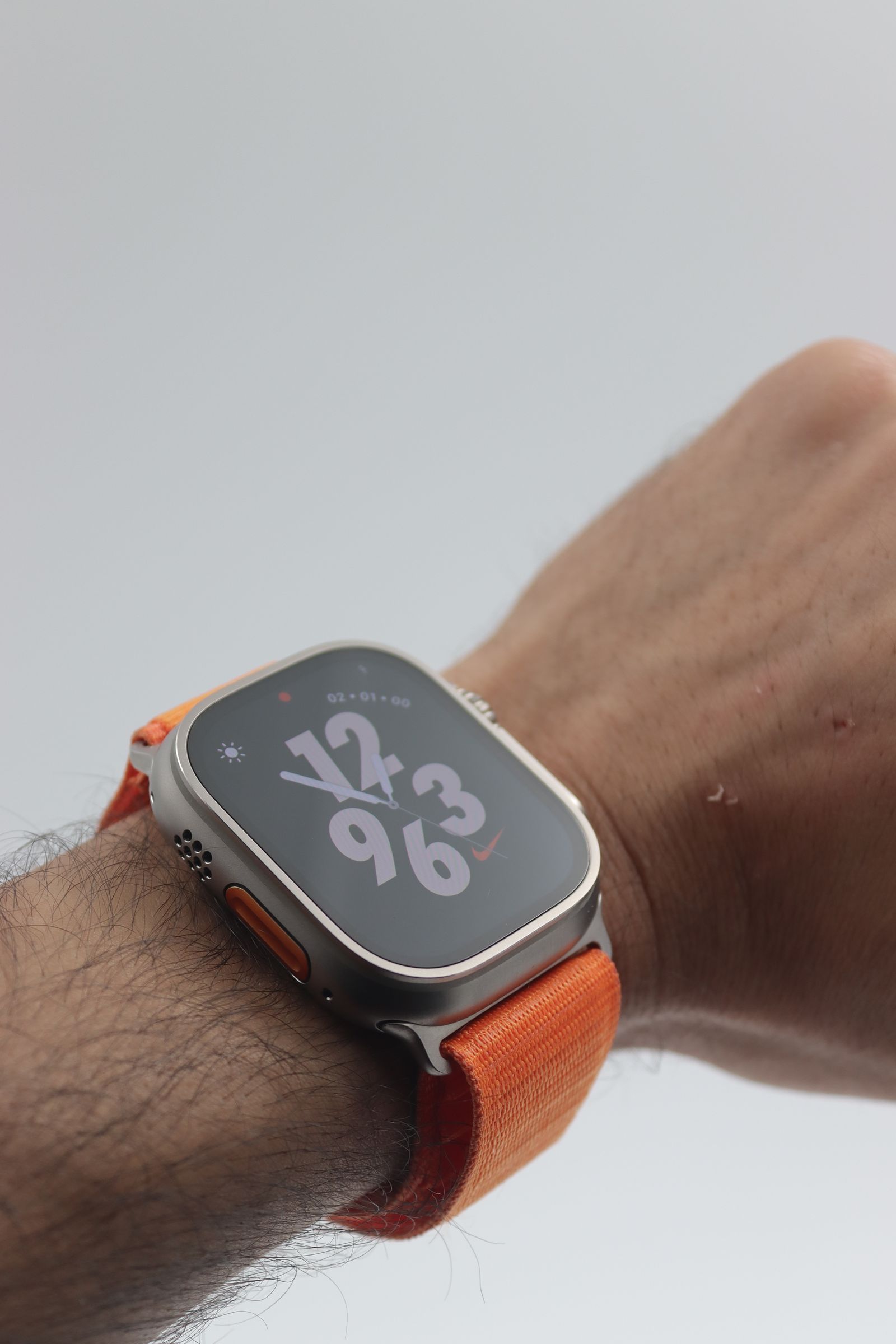 Een smartwatch met oranje band om een pols — sfeerbeeld